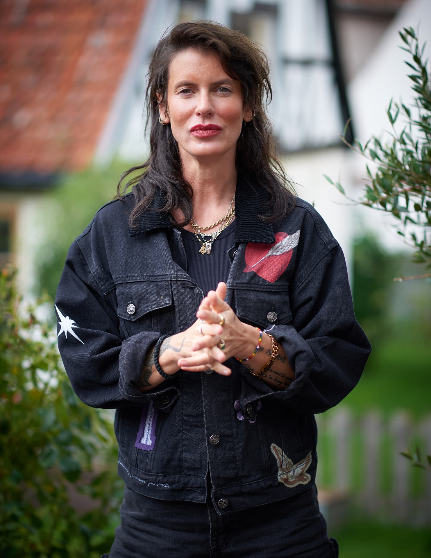 Nina Rung i jeansjacka med patchar i trädgård